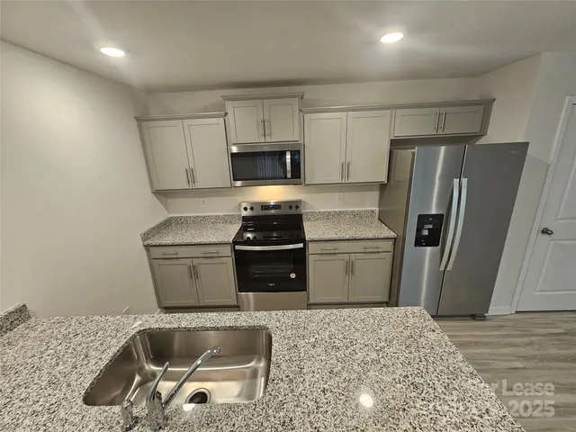 a kitchen with a refrigerator sink and stove