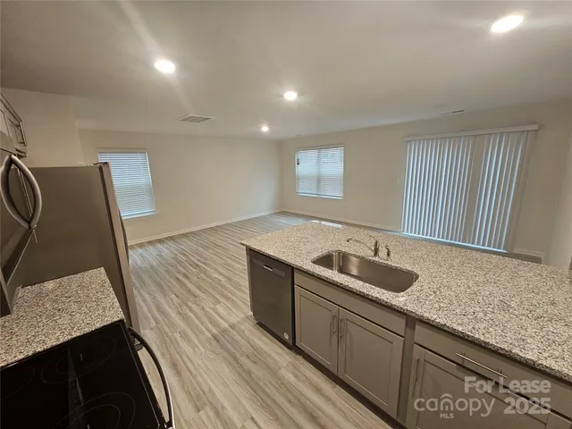 a kitchen with granite countertop stainless steel appliances a sink and stove