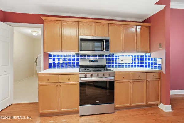 a kitchen with stainless steel appliances granite countertop a stove a sink and a microwave