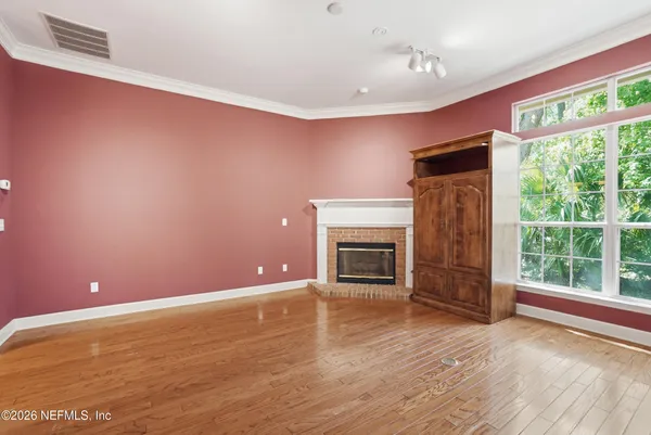 a view of empty room with wooden floor and fireplace