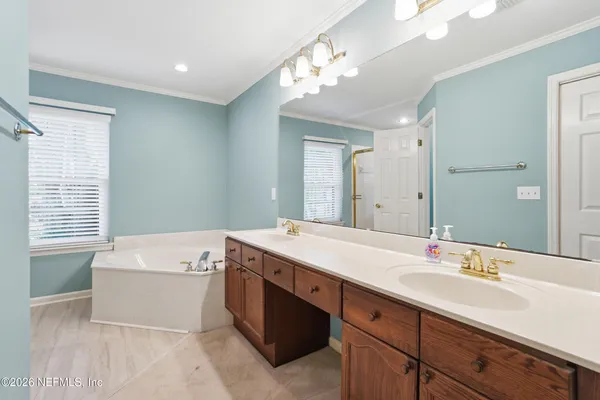 a bathroom with a sink double vanity mirror and bathtub
