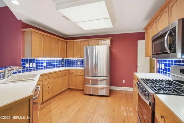 a kitchen with stainless steel appliances granite countertop a refrigerator and a stove top oven