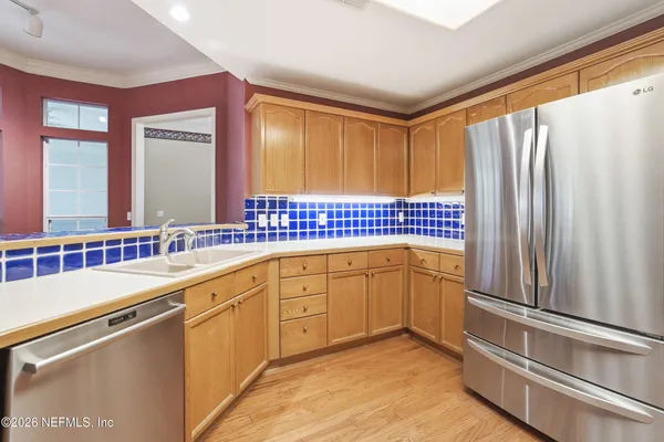 a kitchen with stainless steel appliances a sink cabinets and a window