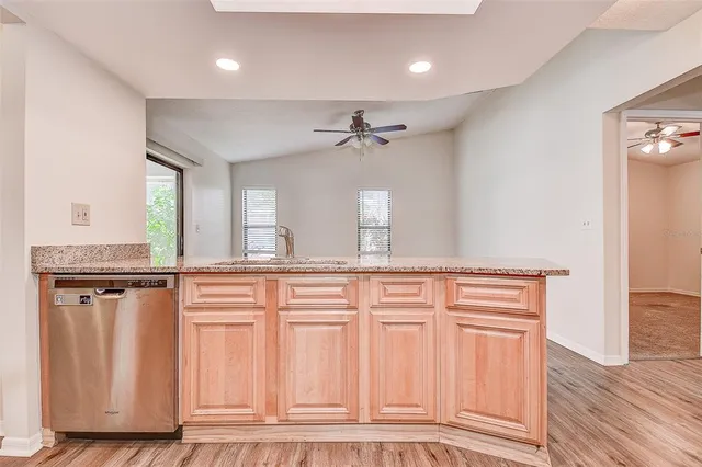 a view of a kitchen with granite countertop cabinets and wooden floor