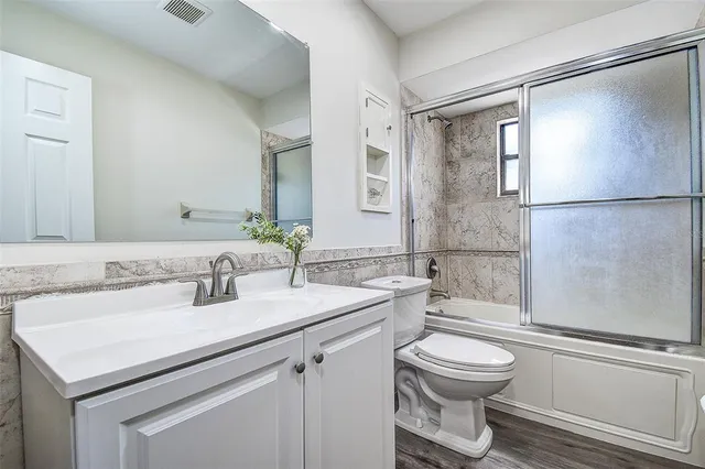 a bathroom with a sink toilet a mirror and shower