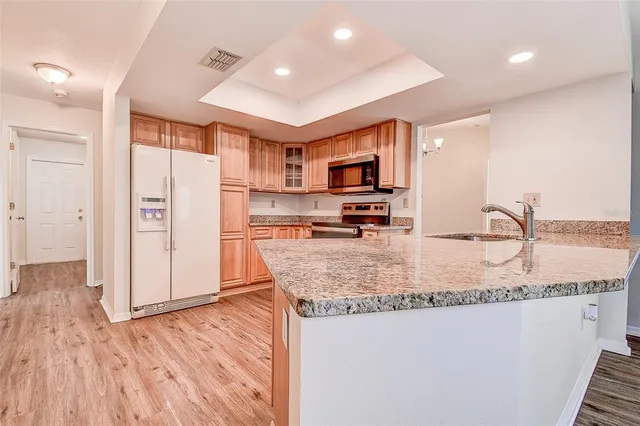 a kitchen with stainless steel appliances granite countertop a sink refrigerator and microwave