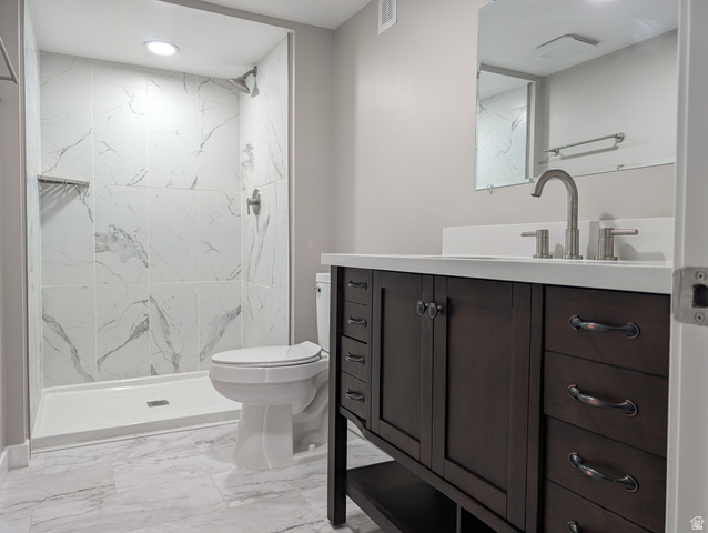 2880 Merton Way Magna, UT 84044 - Photo 19 of 30 Walk-in shower with large format tile surround, a dark wood-finish vanity with ample storage, a white countertop, and brushed nickel fixtures