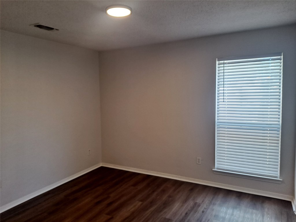 2018 West Rundberg Lane, Unit 9B Austin, TX 78758 - Photo 10 of 23 Empty room with dark wood-type flooring and a textured ceiling