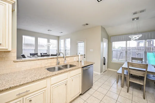 a kitchen with granite countertop a stove sink and refrigerator