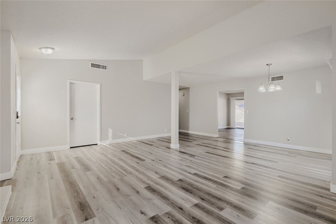 2343 Valleywood Road Henderson, NV 89014 - Photo 14 of 29 The open-concept living area features wide plank flooring and abundant natural illumination, creating an inviting atmosphere.