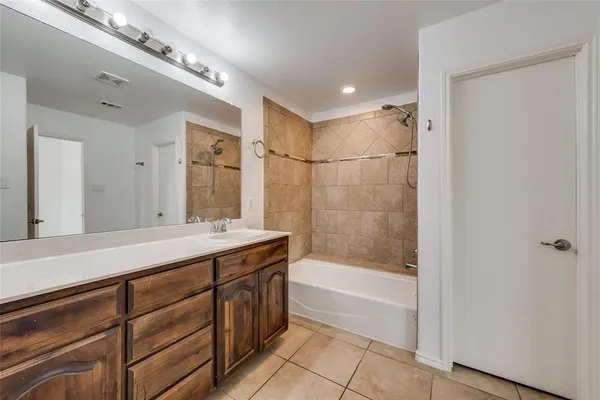 a bathroom with a tub sink shower and mirror