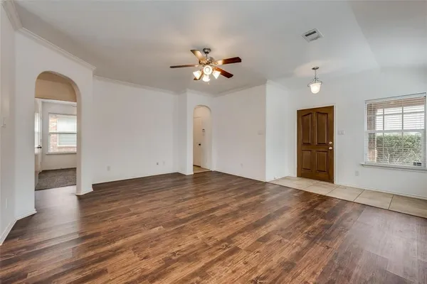 a view of an empty room with window and wooden floor