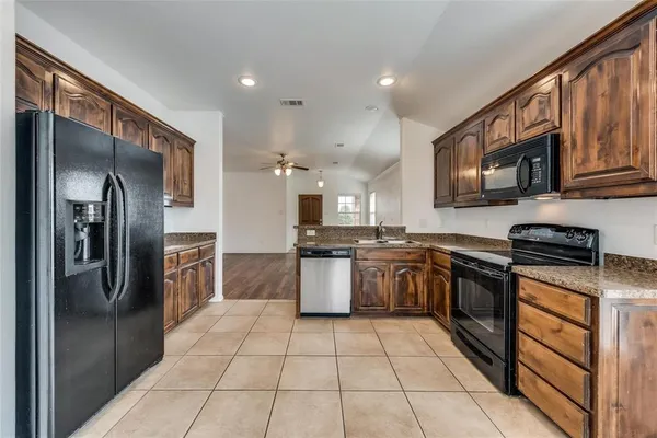 a kitchen with stainless steel appliances granite countertop a refrigerator and a stove top oven