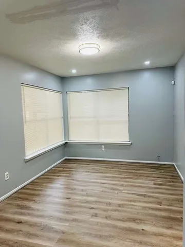 an empty room with a window and a ceiling fan