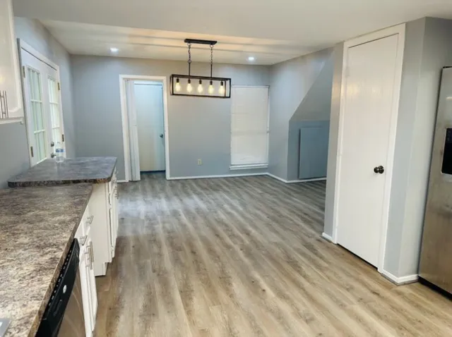 a view of empty room with wooden floor and window