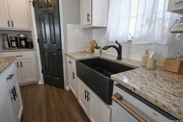 a kitchen with granite countertop a sink dishwasher stove and refrigerator