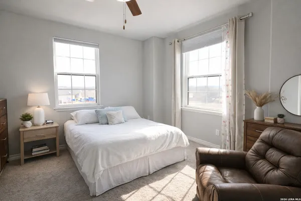 a bedroom with a bed a couch and a window