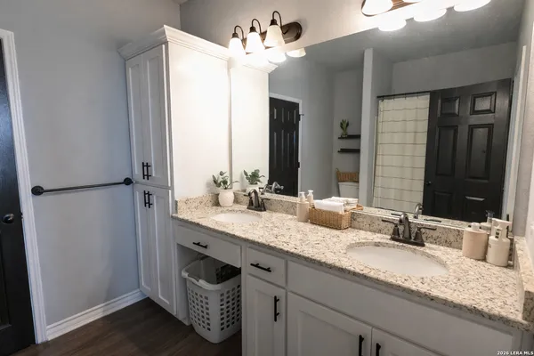 a bathroom with a granite countertop sink and a mirror