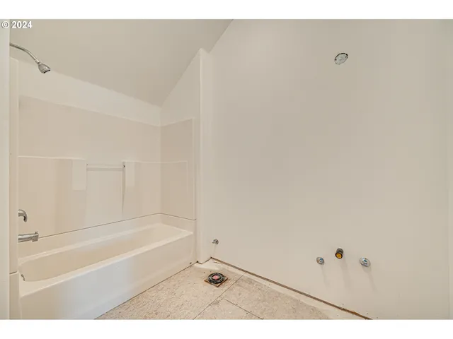 a view of an empty room with wooden floor and windows