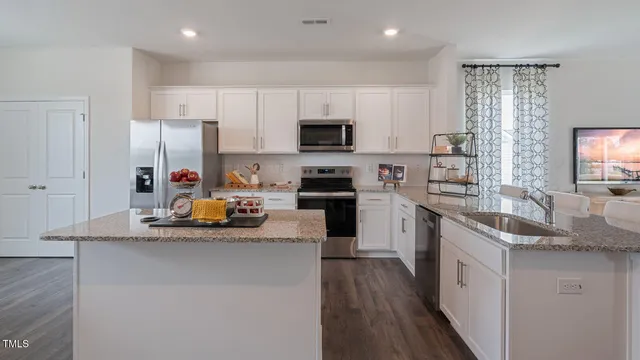 a kitchen with stainless steel appliances granite countertop white cabinets and a stove
