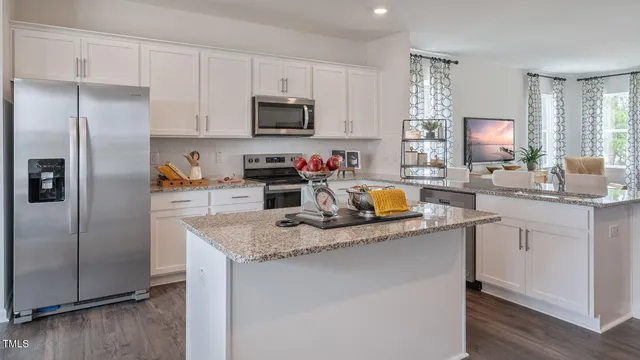 a kitchen with a refrigerator cabinets and wooden floor