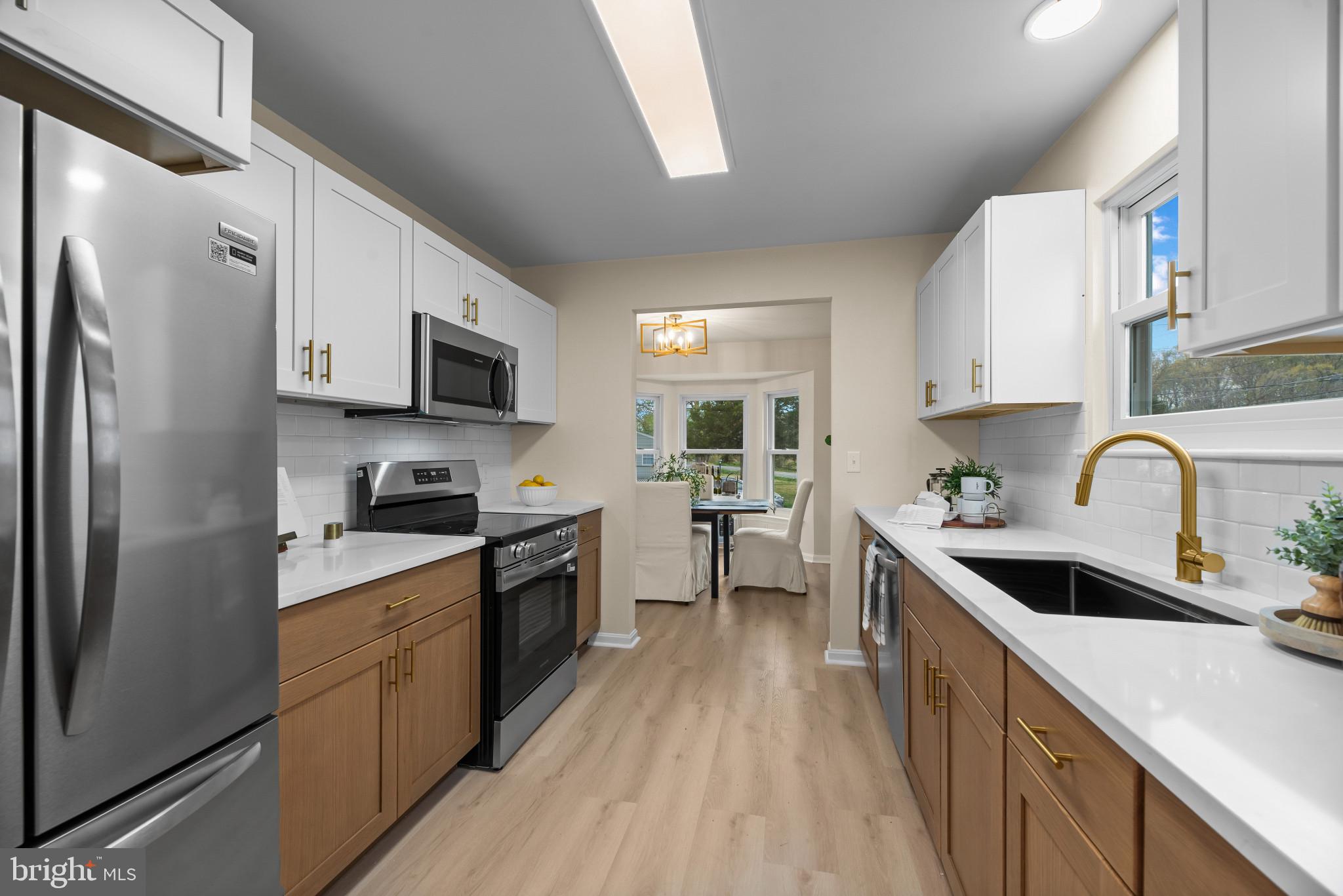 1512 Lincoln Road Shady Side, MD 20764 - Photo 16 of 42 a kitchen with stainless steel appliances granite countertop a refrigerator a stove top oven a sink dishwasher and white cabinets with wooden floor