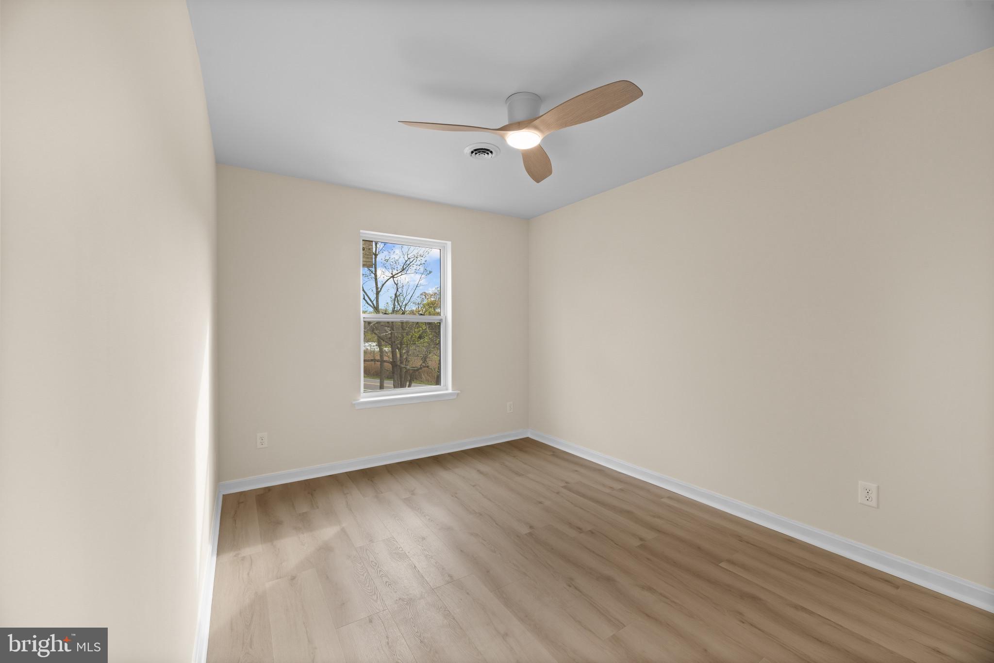 1512 Lincoln Road Shady Side, MD 20764 - Photo 28 of 42 an empty room with wooden floor chandelier fan and windows
