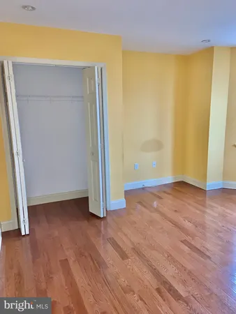 an empty room with wooden floor and closet