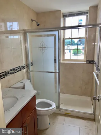 a bathroom with a granite countertop bathtub shower and toilet