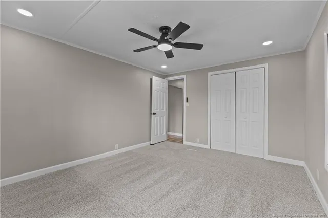 an empty room with ceiling fan and windows