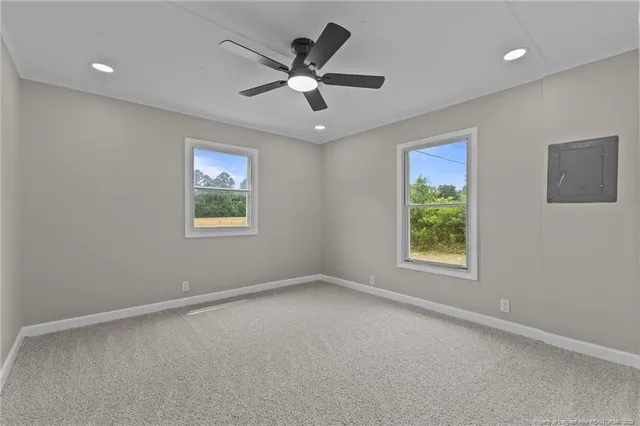 an empty room with a ceiling fan and a window