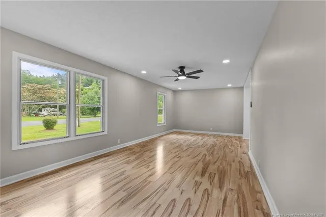 a view of a hallway with wooden floor and a window