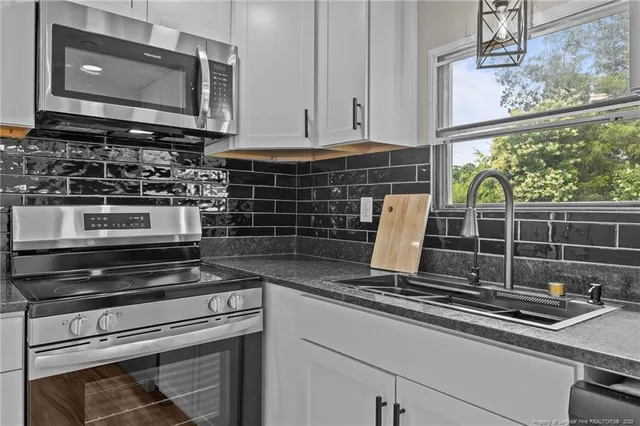 a kitchen with stove top oven and cabinets