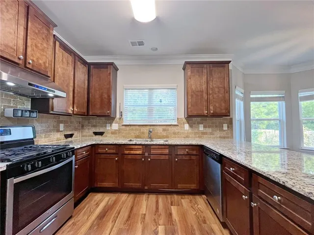 a kitchen with a sink stove and cabinets