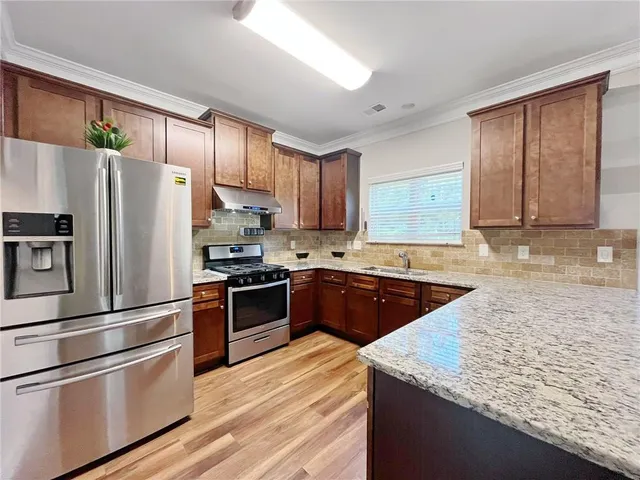 a kitchen with granite countertop stainless steel appliances and wooden cabinets