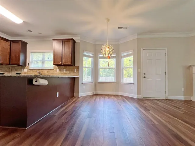 a open kitchen with dishwasher a refrigerator and a stove with wooden floor