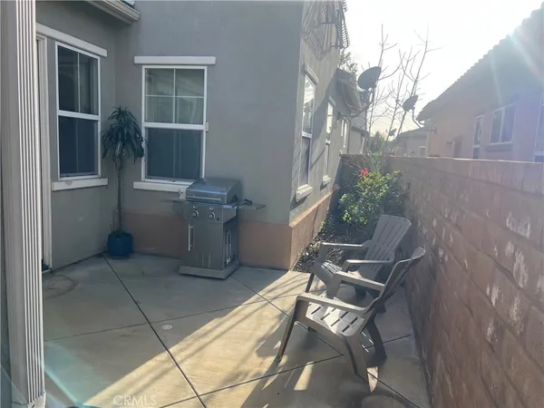 a view of a chair and table in the back yard of the house