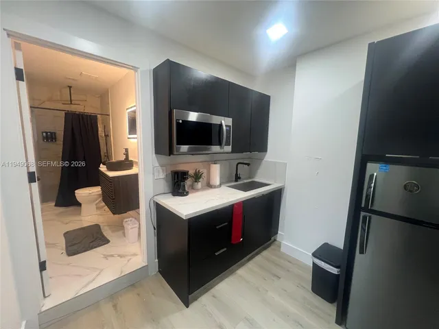 a view of kitchen with sink microwave and refrigerator