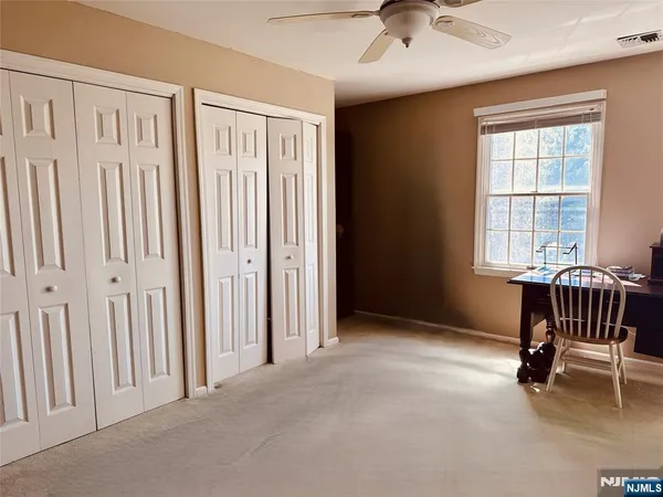 an empty room with windows and fan