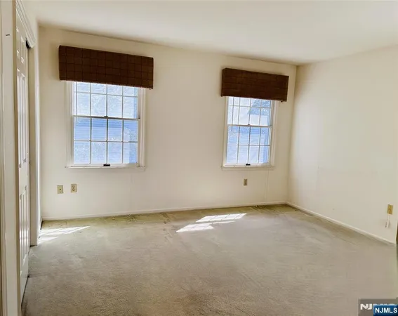an empty room with a window and a dresser