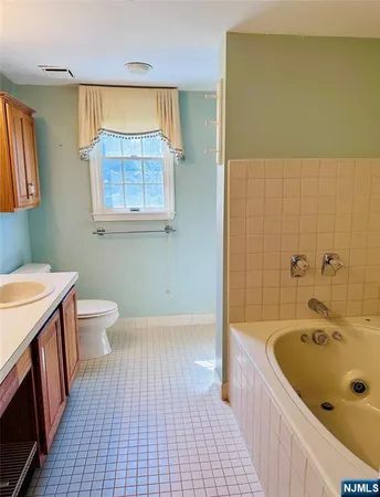 a bathroom with a tub a sink a window and a shower