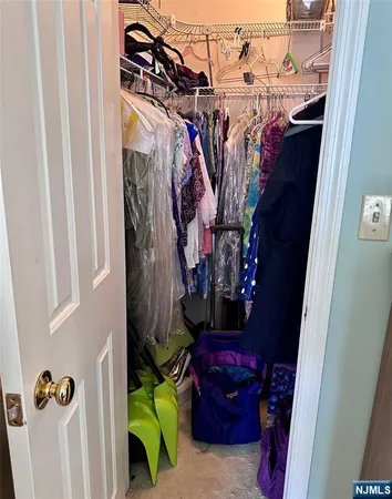 a view of walk in closet with clothes