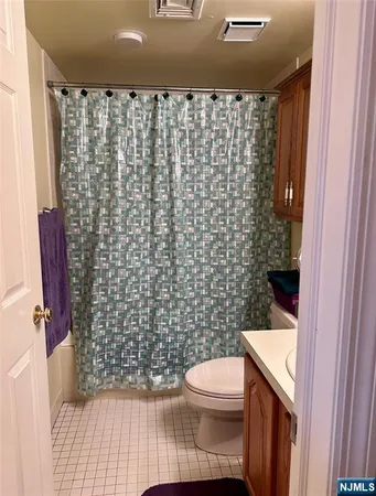 a bathroom with a toilet and a shower curtain