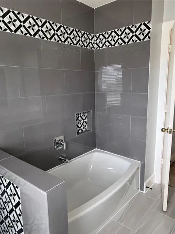 a bathroom with a granite countertop sink and a window