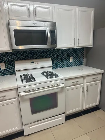 a stove top oven sitting inside of a kitchen