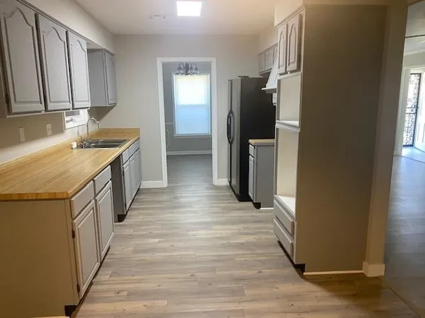 a kitchen with a refrigerator sink and cabinets
