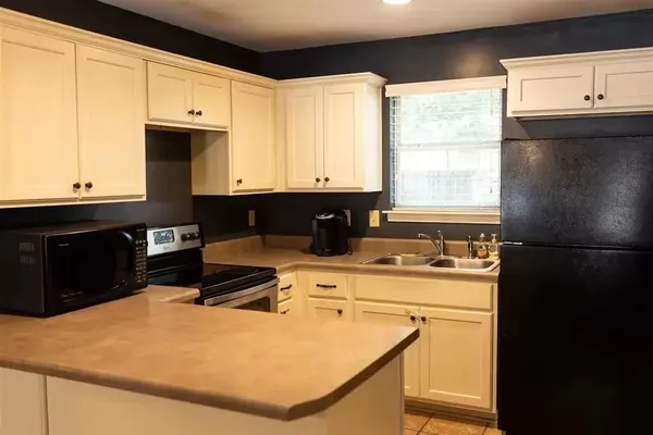 a kitchen with a stove a sink and a microwave