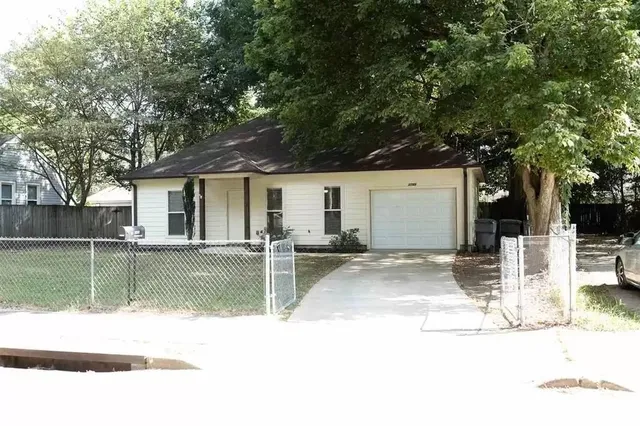a white house that has a tree in front of it