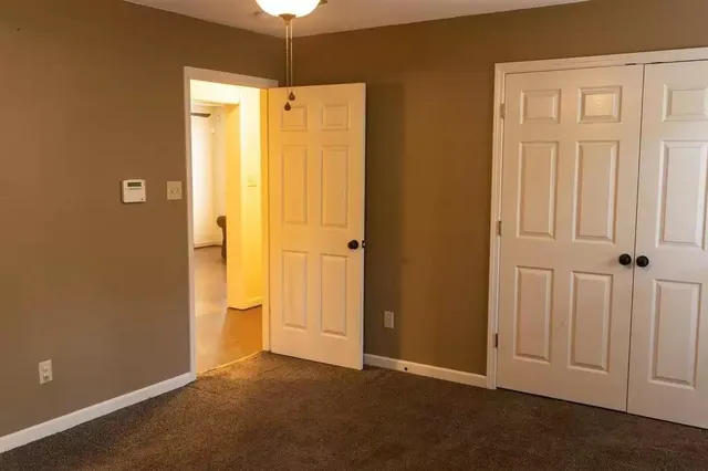 an empty room with windows and closet area