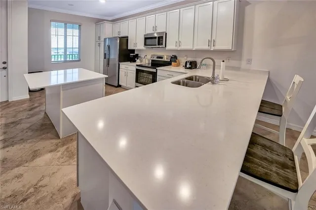 a view of a dining room with furniture and a kitchen